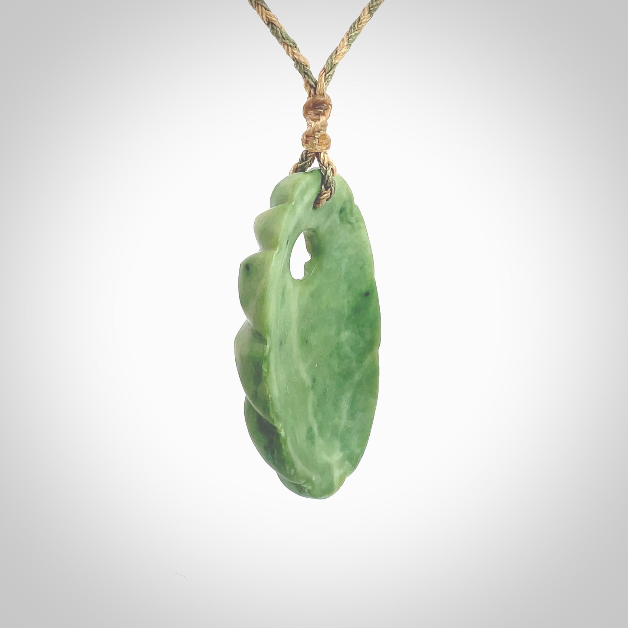 This picture shows a contemporary drop shaped pendant, hand carved from New Zealand flower jade. We will provide this with an adjustable plaited cord. Hand crafted stunning New Zealand Marsden Flower Jade drop pendant by Ana Krakosky.