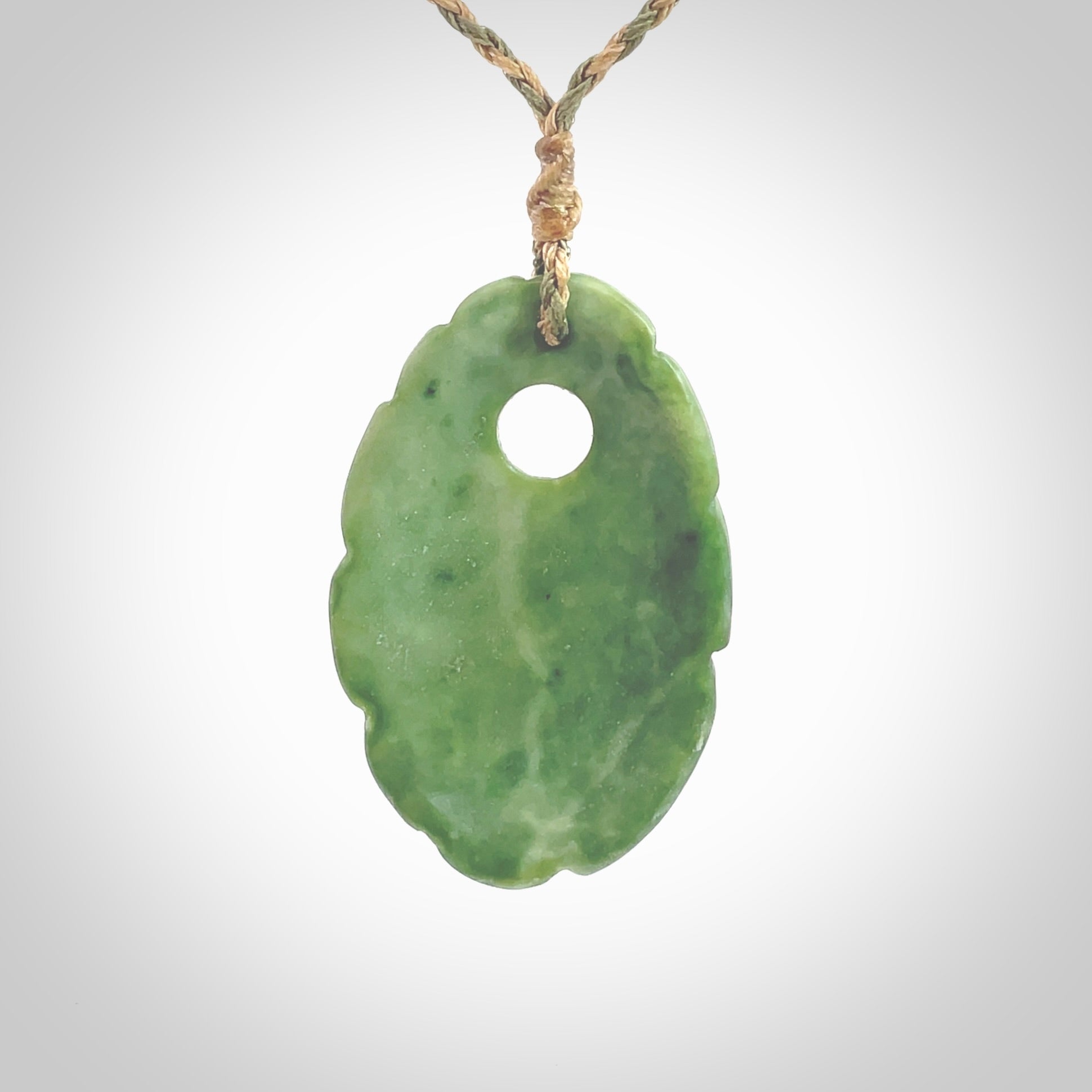 This picture shows a contemporary drop shaped pendant, hand carved from New Zealand flower jade. We will provide this with an adjustable plaited cord. Hand crafted stunning New Zealand Marsden Flower Jade drop pendant by Ana Krakosky.