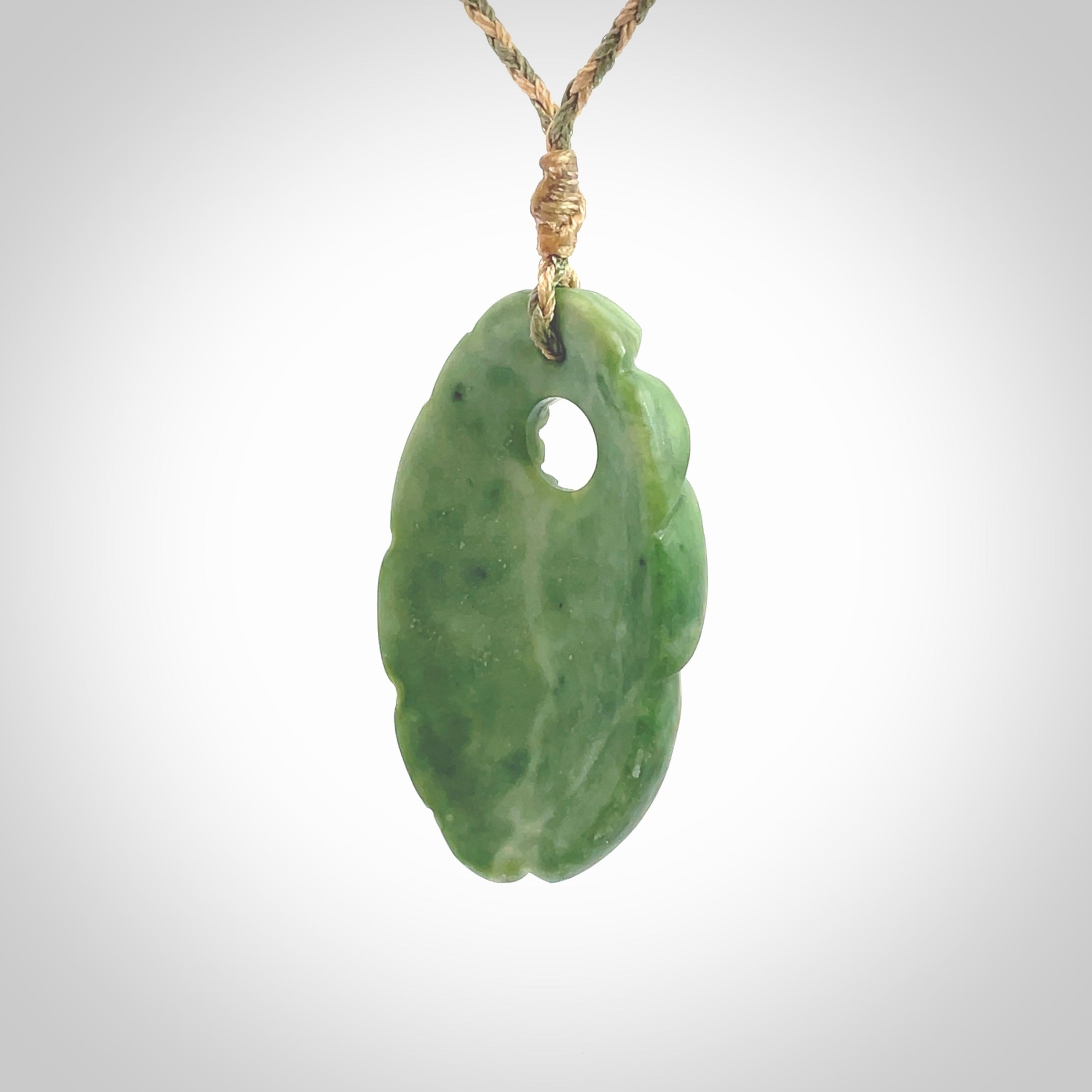 This picture shows a contemporary drop shaped pendant, hand carved from New Zealand flower jade. We will provide this with an adjustable plaited cord. Hand crafted stunning New Zealand Marsden Flower Jade drop pendant by Ana Krakosky.