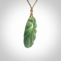 This picture shows a contemporary drop shaped pendant, hand carved from New Zealand flower jade. We will provide this with an adjustable plaited cord. Hand crafted stunning New Zealand Marsden Flower Jade drop pendant by Ana Krakosky.