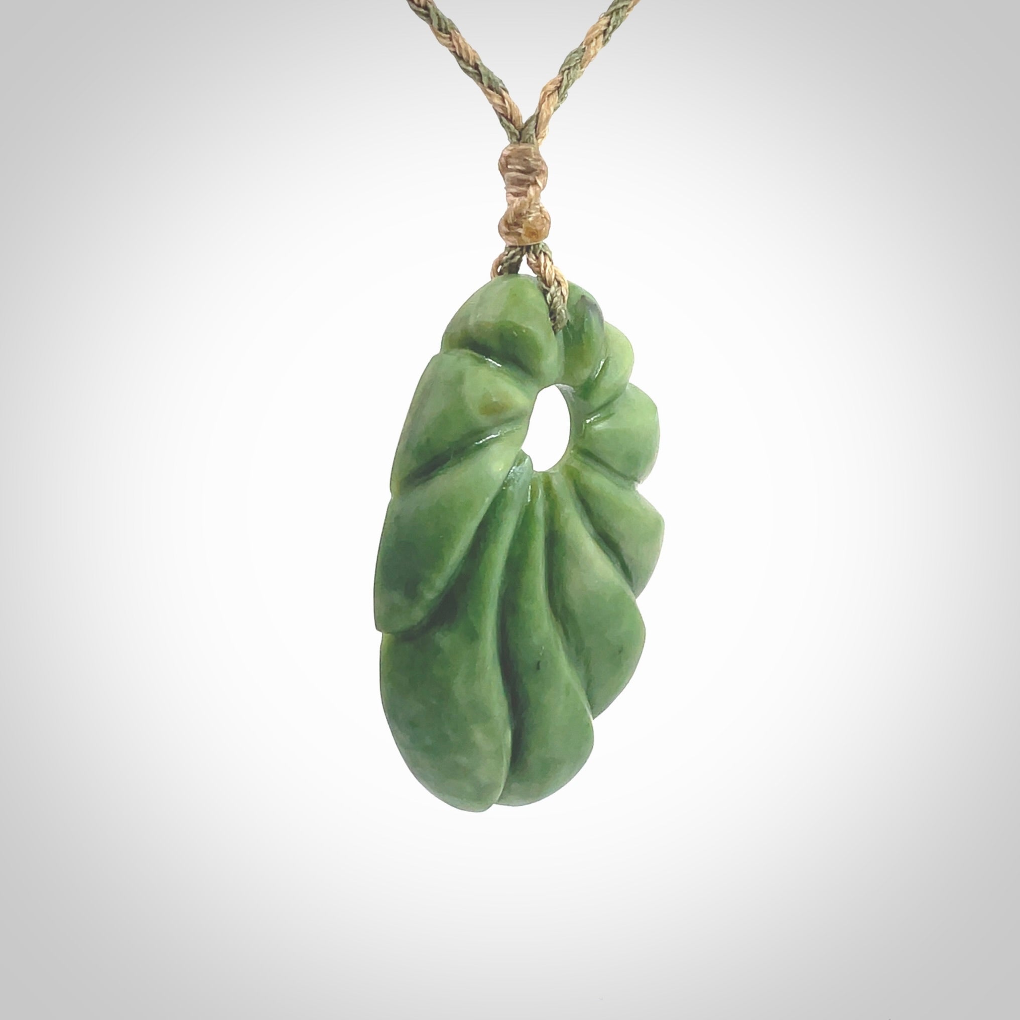 This picture shows a contemporary drop shaped pendant, hand carved from New Zealand flower jade. We will provide this with an adjustable plaited cord. Hand crafted stunning New Zealand Marsden Flower Jade drop pendant by Ana Krakosky.