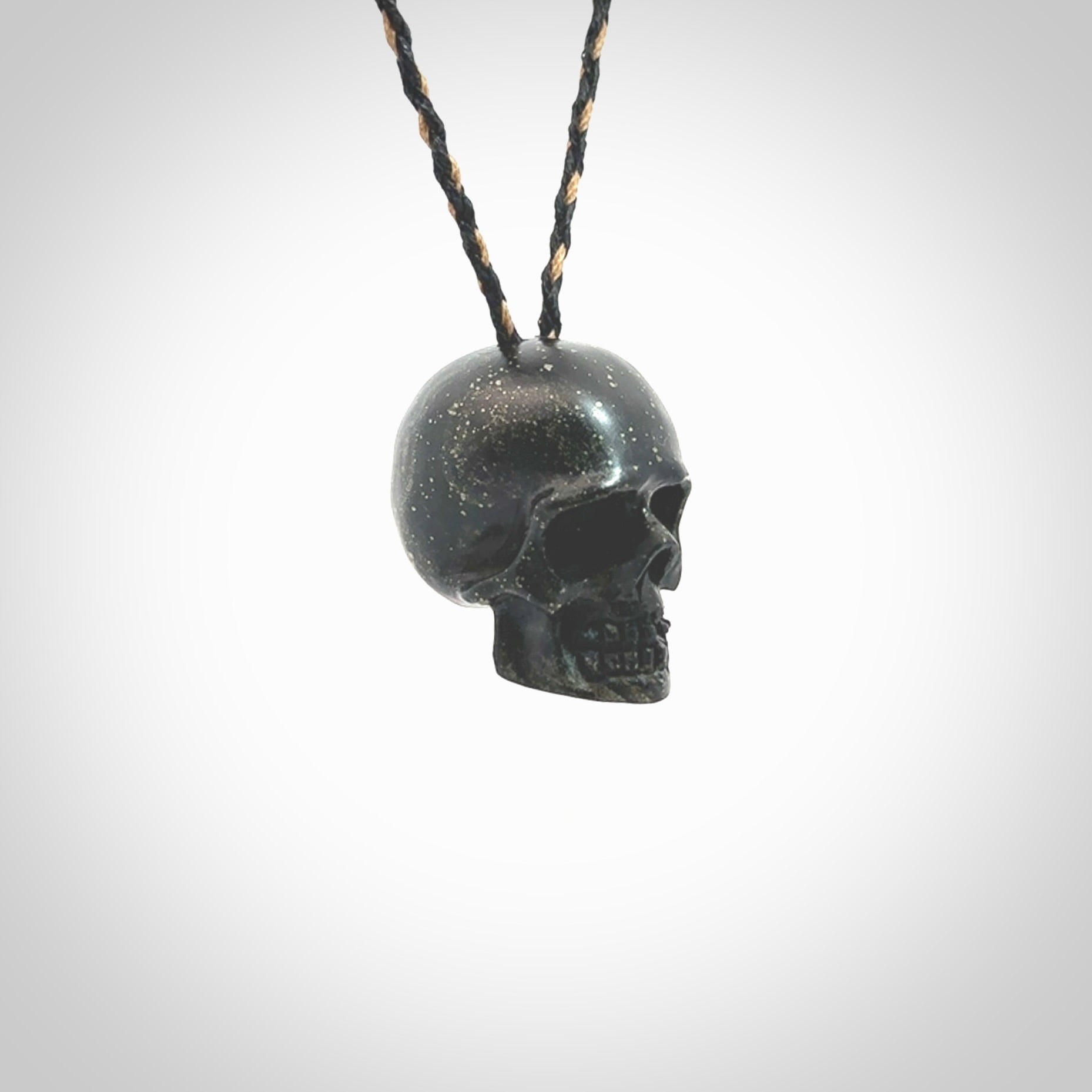 This picture shows a large sized Snowflake Obsidian stone skull pendant that we have hand carved. It is polished to a soft shine and is a very striking piece. Provided with an adjustable black and tan cord.