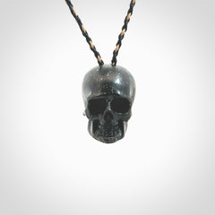 This picture shows a large sized Snowflake Obsidian stone skull pendant that we have hand carved. It is polished to a soft shine and is a very striking piece. Provided with an adjustable black and tan cord.