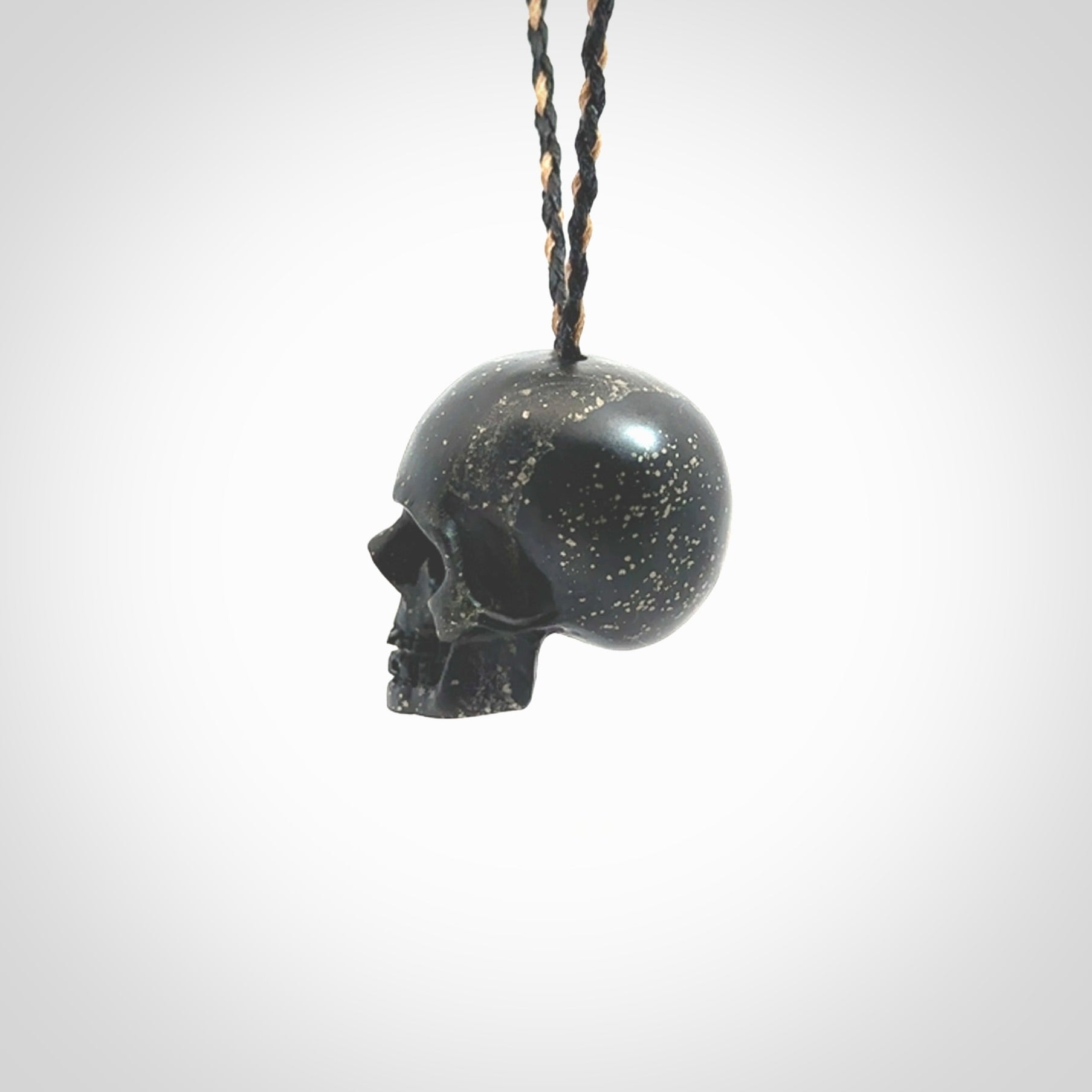 This picture shows a large sized Snowflake Obsidian stone skull pendant that we have hand carved. It is polished to a soft shine and is a very striking piece. Provided with an adjustable black and tan cord.