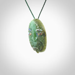 This picture shows a hand carved Jade with paua shell face pendant. It is a varied green colour which is quite beautiful. Although a medium piece, it is a wonderful, delicate piece of jewellery. The cord is hand plaited and adjustable so that you can position the pendant where it suits you best. Delivery is free worldwide.