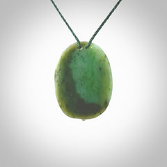 This picture shows a hand carved Jade with paua shell face pendant. It is a varied green colour which is quite beautiful. Although a medium piece, it is a wonderful, delicate piece of jewellery. The cord is hand plaited and adjustable so that you can position the pendant where it suits you best. Delivery is free worldwide.