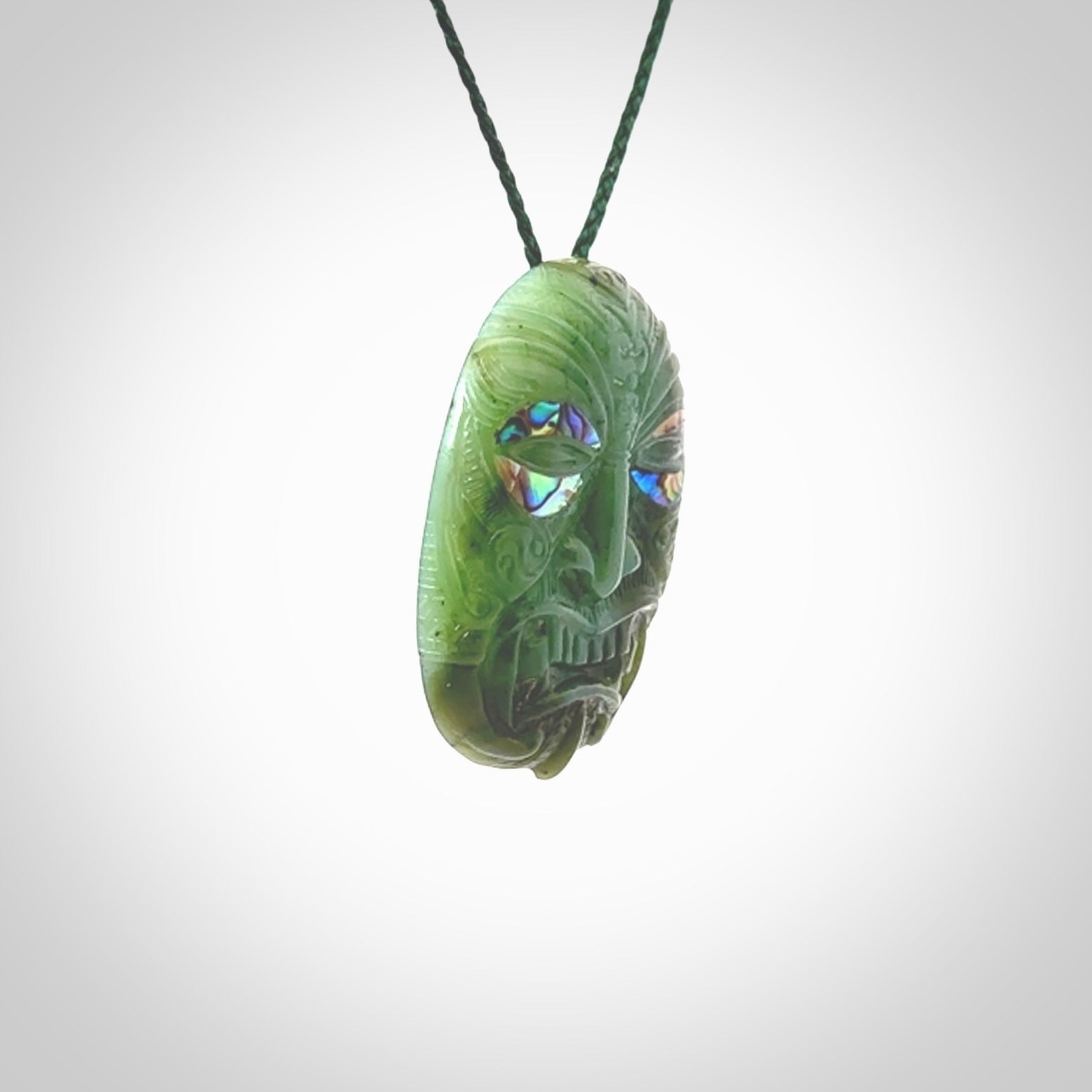 This picture shows a hand carved Jade with paua shell face pendant. It is a varied green colour which is quite beautiful. Although a medium piece, it is a wonderful, delicate piece of jewellery. The cord is hand plaited and adjustable so that you can position the pendant where it suits you best. Delivery is free worldwide.