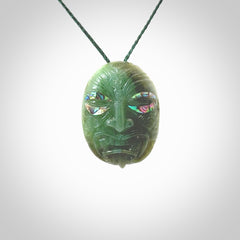 This picture shows a hand carved Jade with paua shell face pendant. It is a varied green colour which is quite beautiful. Although a medium piece, it is a wonderful, delicate piece of jewellery. The cord is hand plaited and adjustable so that you can position the pendant where it suits you best. Delivery is free worldwide.