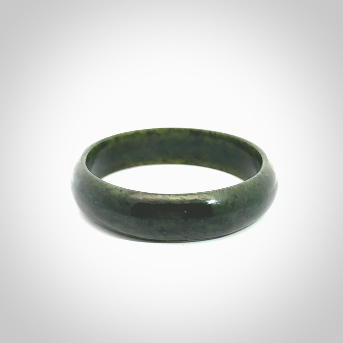 Hand carved jade bangle. Carved from green New Zealand jade. This is a solid jade bangle carved from a single piece of jade. It is polished to a soft shine. The jade is otherwise untreated and completely natural.