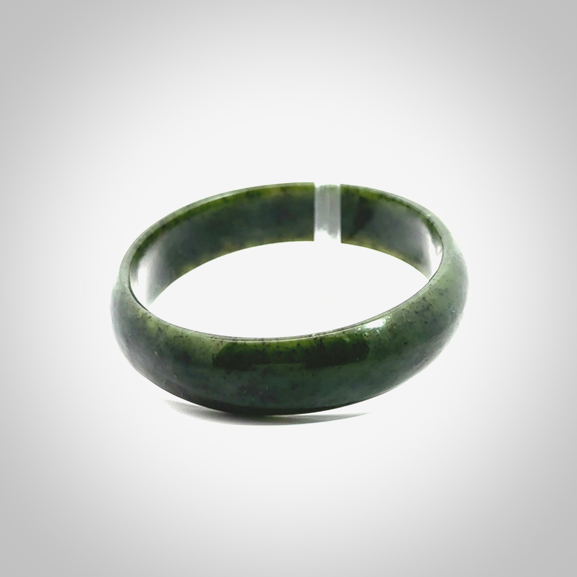 Hand carved jade bangle. Carved from green New Zealand jade. This is a solid jade bangle carved from a single piece of jade. It is polished to a soft shine. The jade is otherwise untreated and completely natural.