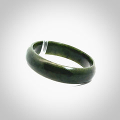 Hand carved jade bangle. Carved from green New Zealand jade. This is a solid jade bangle carved from a single piece of jade. It is polished to a soft shine. The jade is otherwise untreated and completely natural.