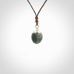 This picture shows a little jade acorn pendant. The cap is sterling silver and is embossed with some decorative markings which give the silver cap some detail and character. Hand made by Ana Krakosky.