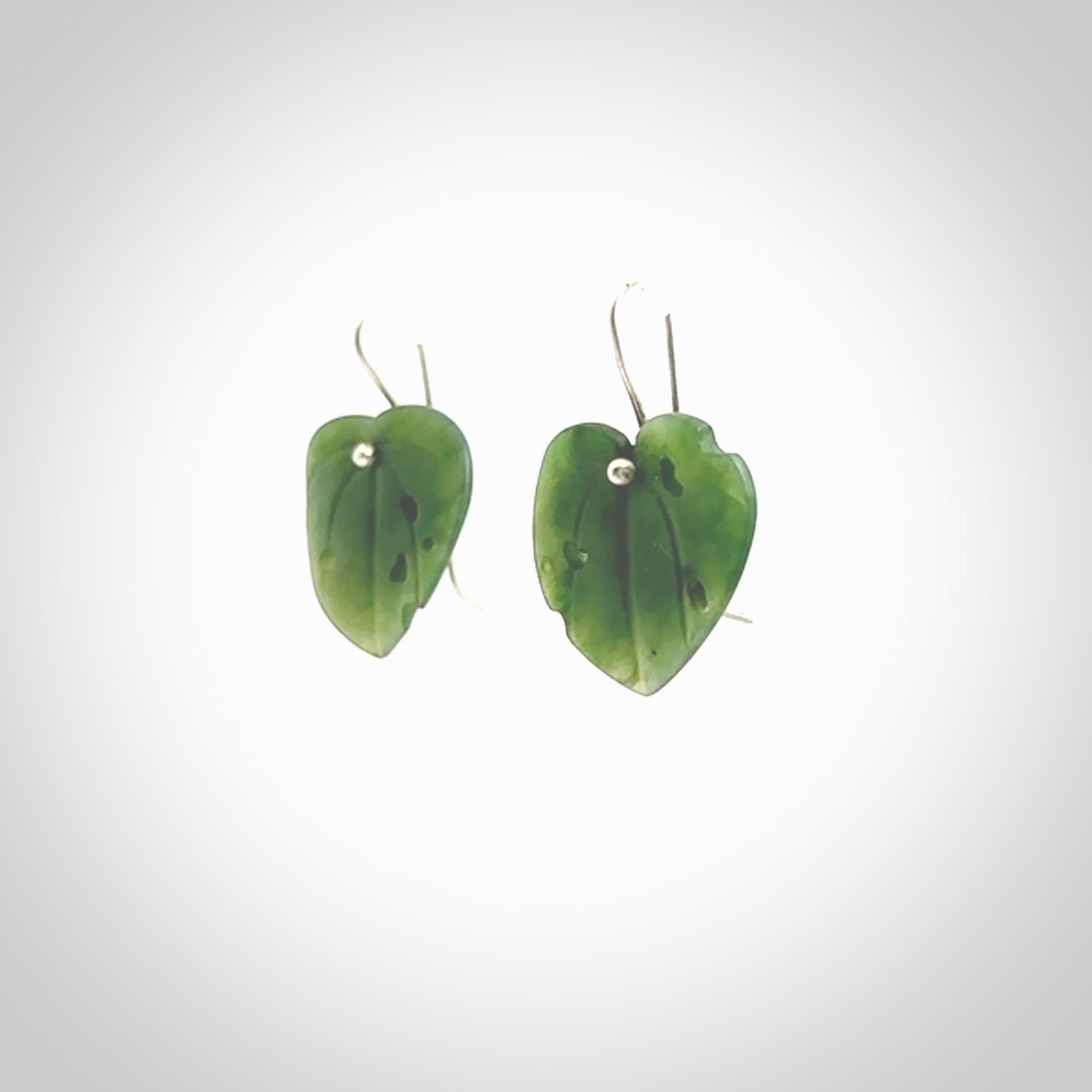 These are stunning heart shaped jade kawakawa leaf earrings carved in New Zealand by Josey Coyle. It is carved from a deep green piece of New Zealand Jade and with Sterling Silver hooks.