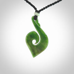 This photo shows a beautiful jade swan hook suspended from a hand plaited black cord. This swan hook was carved for us by Jen Hung who is a master jade carver from New Zealand.