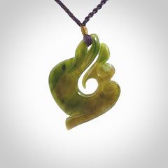 This photo shows a beautiful jade swan hook suspended from a hand plaited purple/brown cord. This swan hook was carved for us by Jen Hung who is a master jade carver from New Zealand.