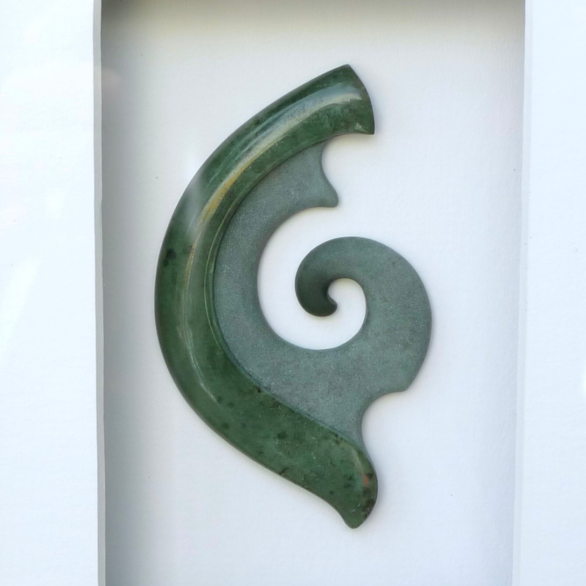 A hand carved large New Zealand Jade Koru necklace that has been framed and signed by artist Kerry Thompson. A large sized hand made koru necklace by New Zealand artist Kerry Thompson. One off framed work of art to wear. Delivered with Express Courier.