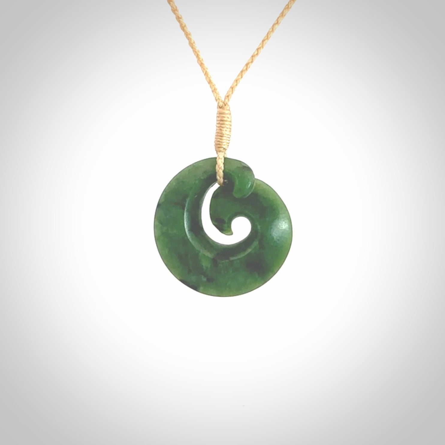 This picture shows a koru pendant, hand carved from New Zealand jade. We will provide this with an adjustable plaited cord. This has been hand carved by Kyohei Noguchi. One only pendant, shipped to you with express courier.