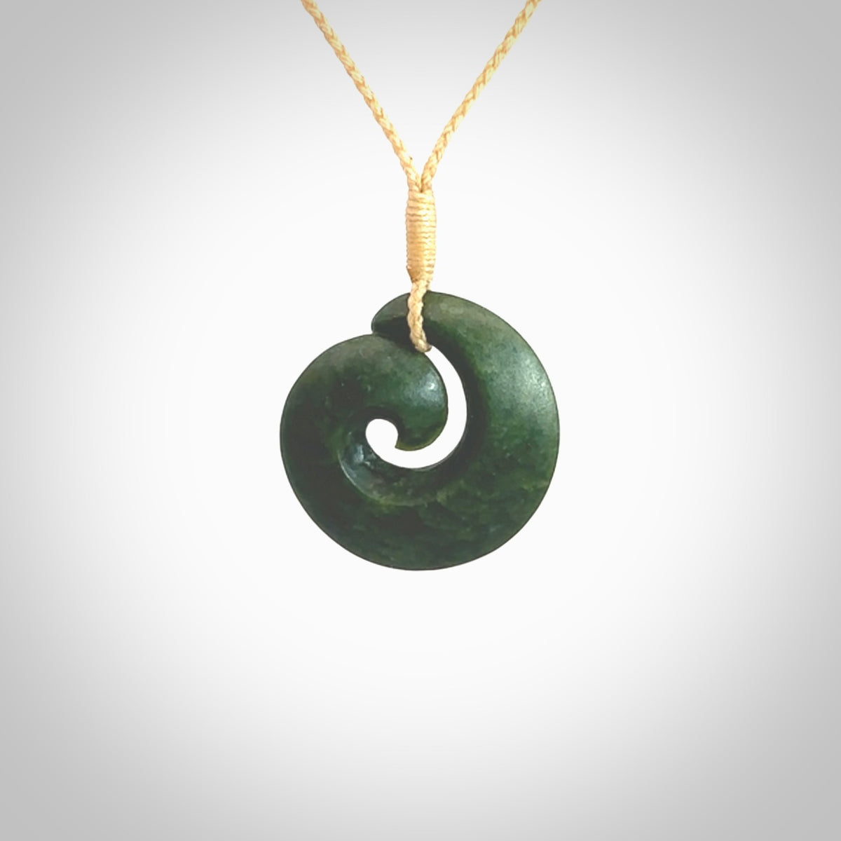 This picture shows a koru pendant, hand carved from New Zealand jade. We will provide this with an adjustable plaited cord. This has been hand carved by Kyohei Noguchi. One only pendant, shipped to you with express courier.