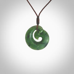 This picture shows a koru pendant, hand carved from New Zealand jade. We will provide this with an adjustable plaited cord. This has been hand carved by Kyohei Noguchi. One only pendant, shipped to you with express courier.