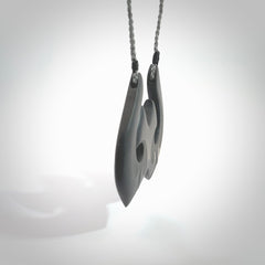 A hand carved large New Zealand Argillite double Hook, Matau, necklace. The cord is a grey colour and is adjustable in length. A large sized hand made double hook necklace by New Zealand artist Rueben Tipene. One off work of art to wear.