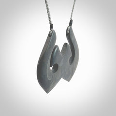 A hand carved large New Zealand Argillite double Hook, Matau, necklace. The cord is a grey colour and is adjustable in length. A large sized hand made double hook necklace by New Zealand artist Rueben Tipene. One off work of art to wear.