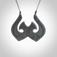 A hand carved large New Zealand Argillite double Hook, Matau, necklace. The cord is a grey colour and is adjustable in length. A large sized hand made double hook necklace by New Zealand artist Rueben Tipene. One off work of art to wear.