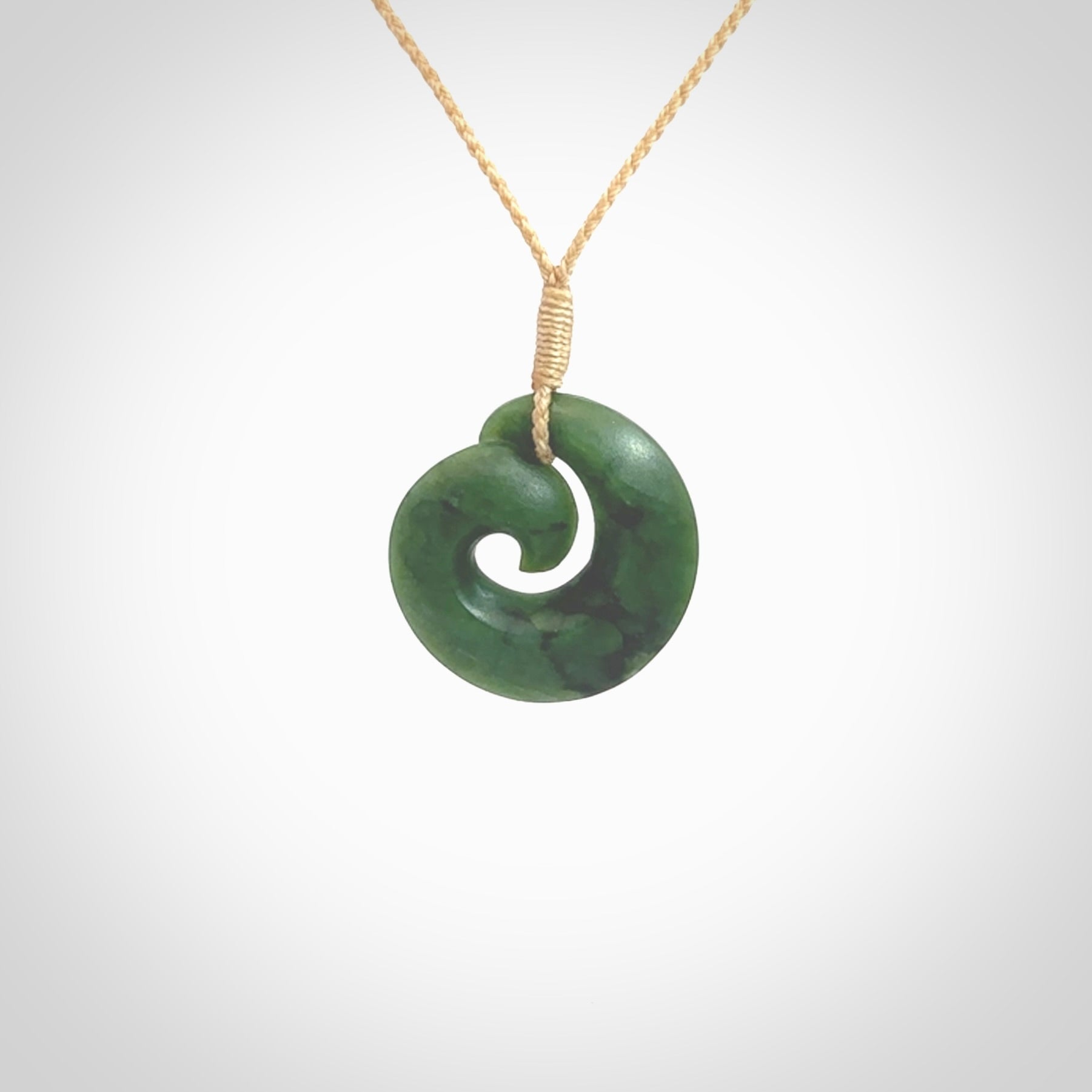 This picture shows a koru pendant, hand carved from New Zealand jade. We will provide this with an adjustable plaited cord. This has been hand carved by Kyohei Noguchi. One only pendant, shipped to you with express courier.