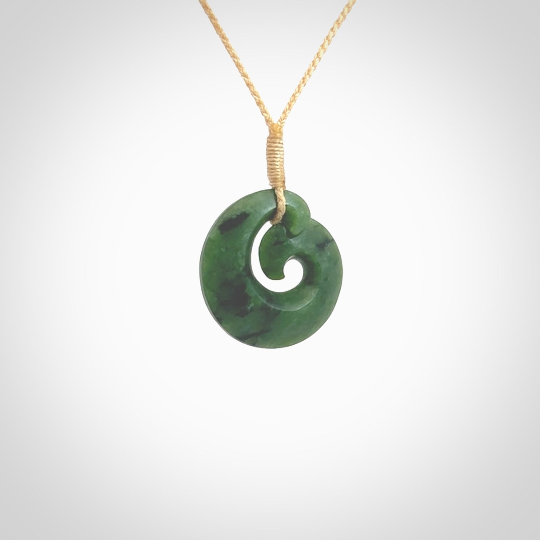 This picture shows a koru pendant, hand carved from New Zealand jade. We will provide this with an adjustable plaited cord. This has been hand carved by Kyohei Noguchi. One only pendant, shipped to you with express courier.