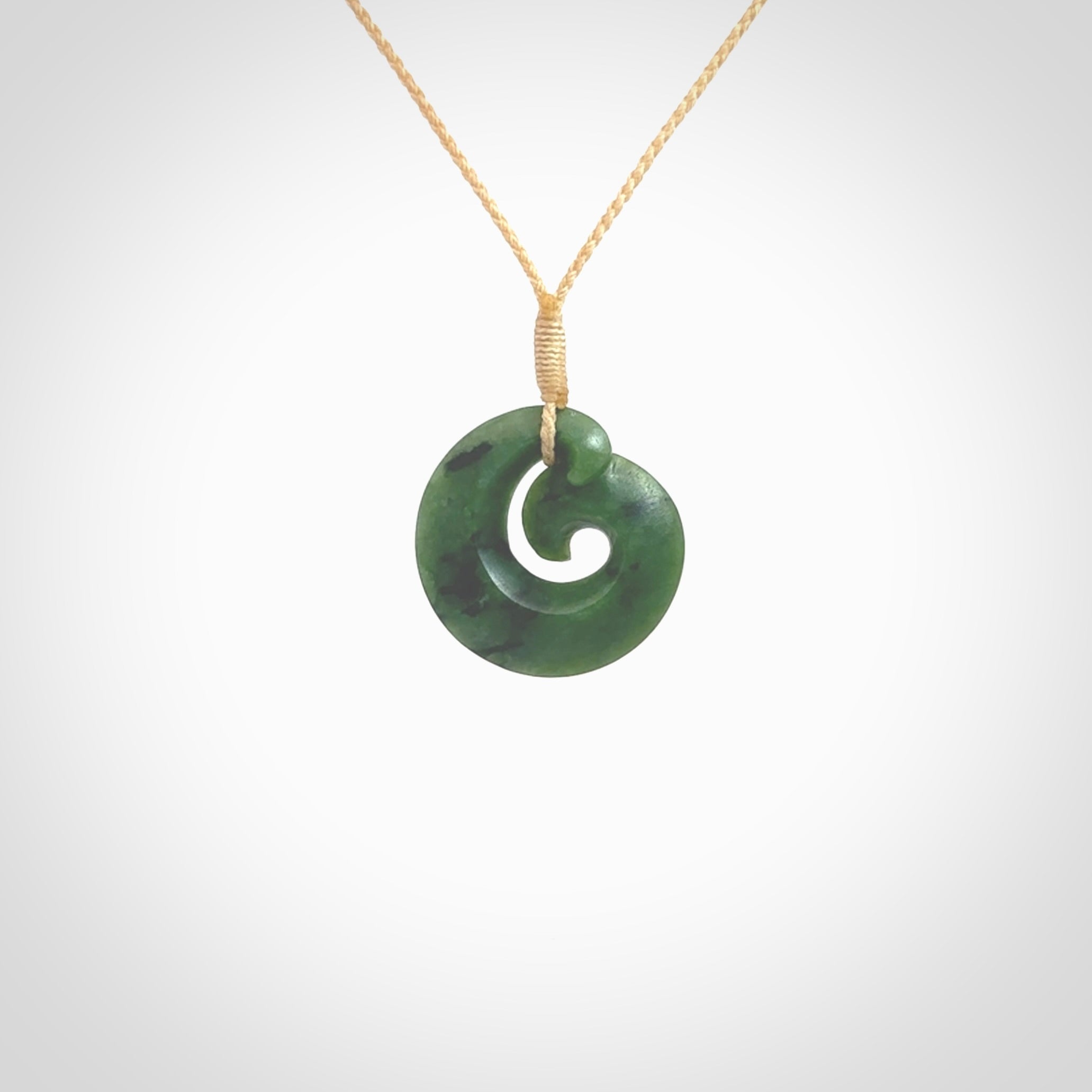 This picture shows a koru pendant, hand carved from New Zealand jade. We will provide this with an adjustable plaited cord. This has been hand carved by Kyohei Noguchi. One only pendant, shipped to you with express courier.