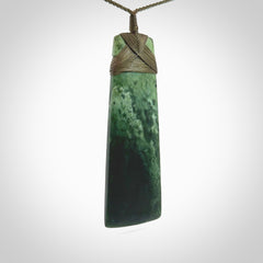 This large Toki is hand carved from a lovely piece of local New Zealand Jade. The quality of the workmanship and design is outstanding - this is a piece you will want to wear all the time. We have suspended this from a 4-plait olive green cord which can be adjusted with a couple of slip knots and olive binding. Hand made by Kyohei Noguchi.