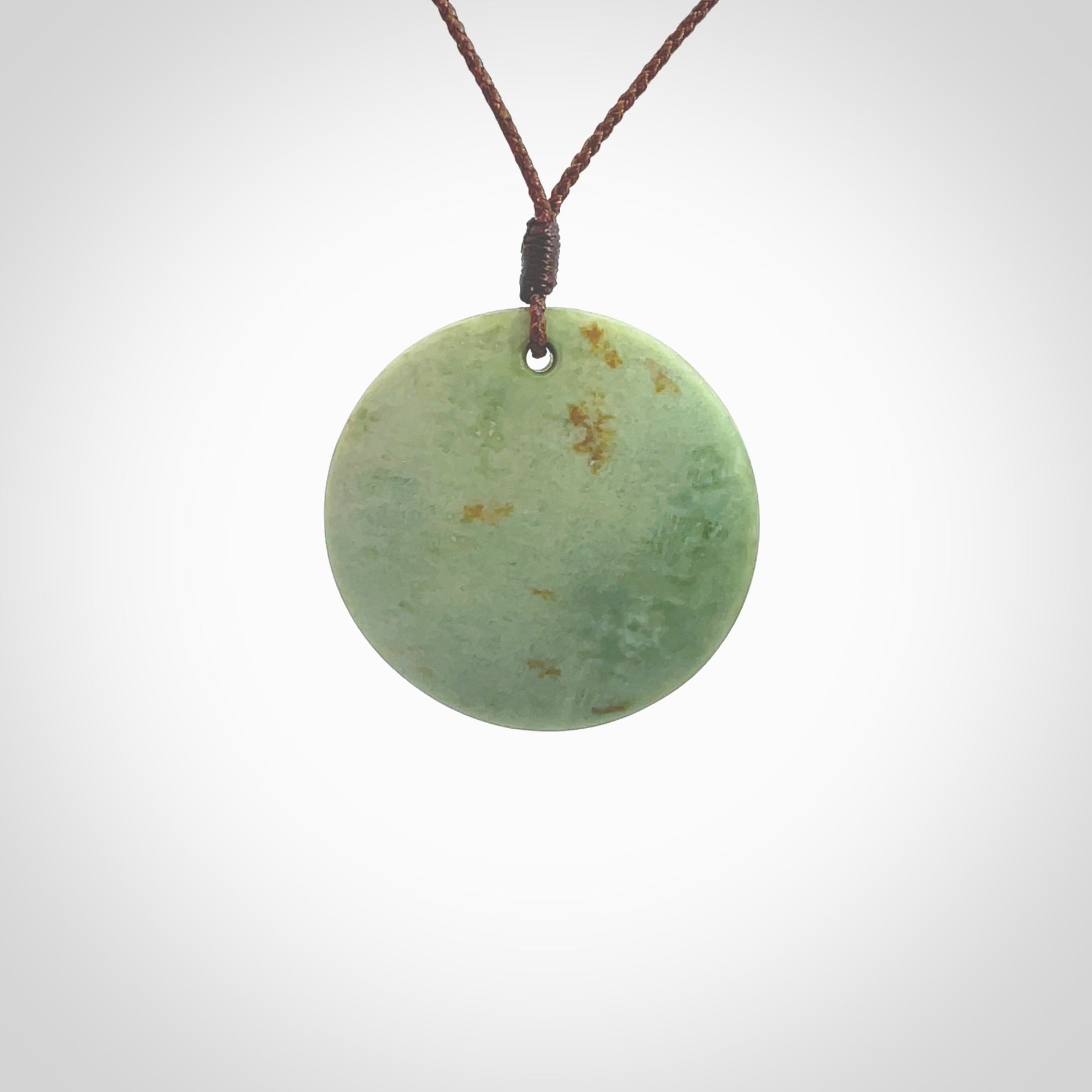 This pendant is a medium sized and cupped koru necklace carved from a lovely light green piece of New Zealand Marsden Flower Jade. Kyohei Noguchi carved this piece for us so the workmanship is outstanding. Handmade in New Zealand, a beautiful piece of jade jewellery. Provided with an adjustable brown cord and packaged in a woven kete pouch.