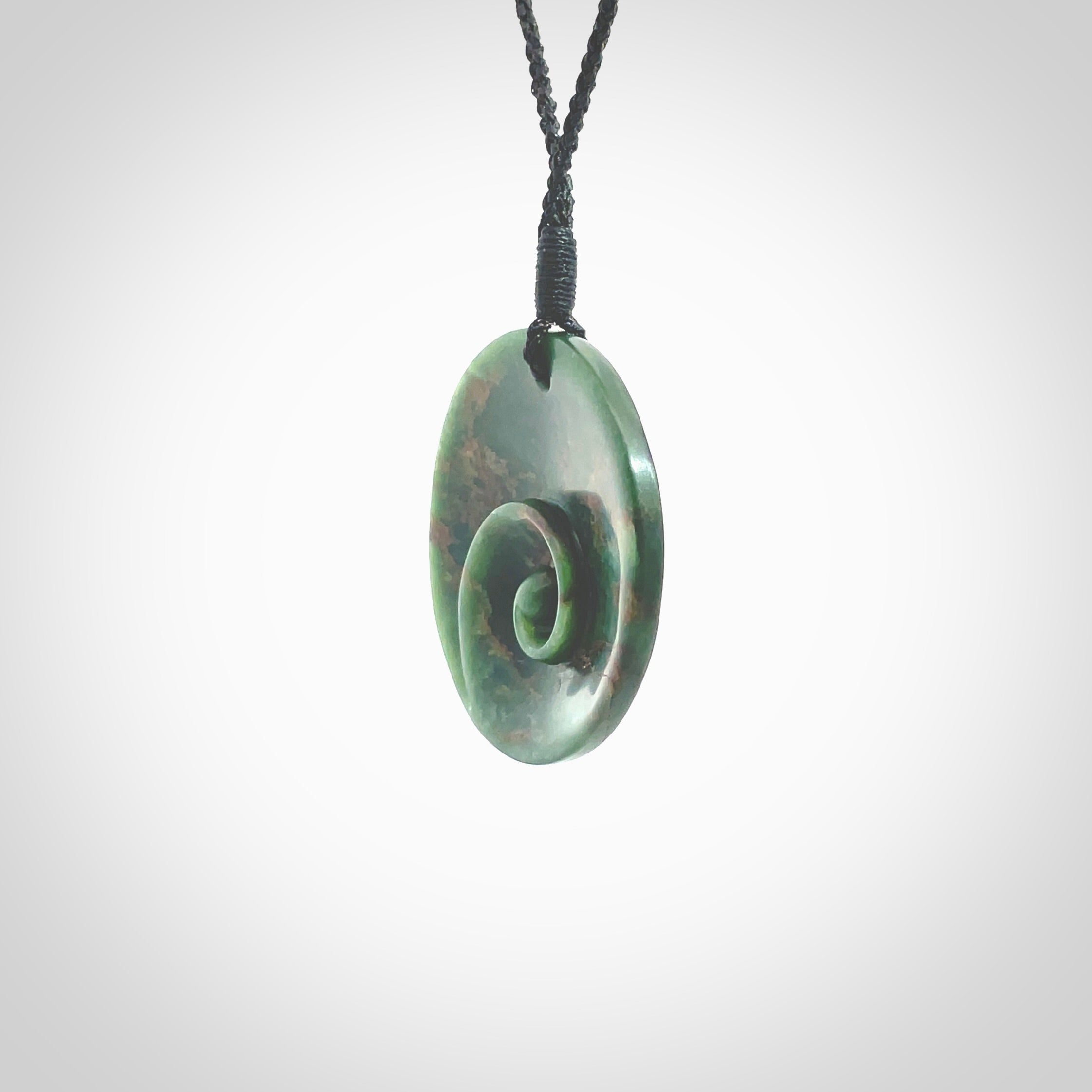 This pendant is a large sized and cupped koru necklace carved from a dark green piece of New Zealand Marsden Flower Jade. Kyohei Noguchi carved this piece for us so the workmanship is outstanding. Handmade in New Zealand, a beautiful piece of jade jewellery. Provided with an adjustable black cord and packaged in a woven kete pouch.