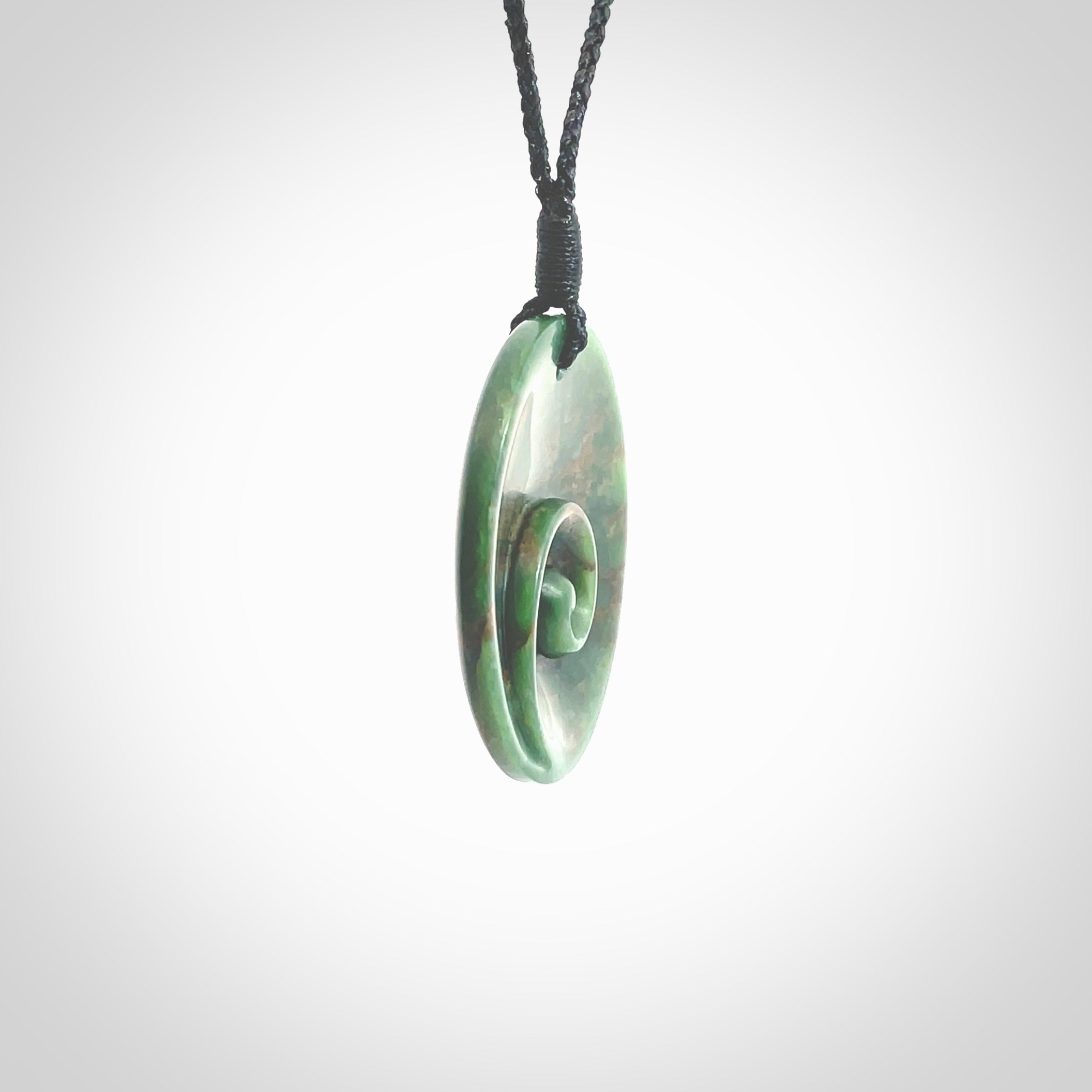 This pendant is a large sized and cupped koru necklace carved from a dark green piece of New Zealand Marsden Flower Jade. Kyohei Noguchi carved this piece for us so the workmanship is outstanding. Handmade in New Zealand, a beautiful piece of jade jewellery. Provided with an adjustable black cord and packaged in a woven kete pouch.