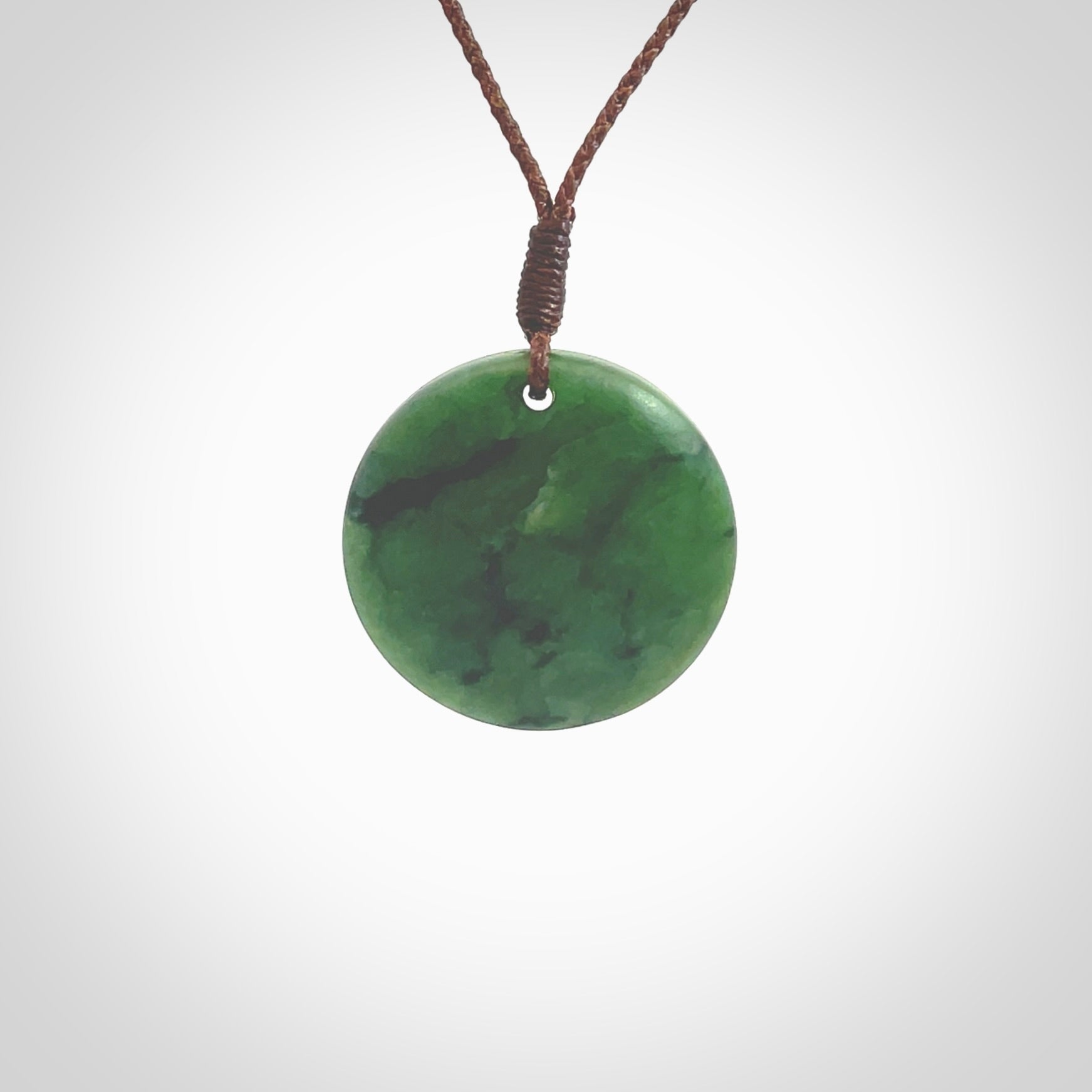 This pendant is a small sized and cupped koru necklace carved from a dark green piece of New Zealand Marsden Jade. Kyohei Noguchi carved this piece for us so the workmanship is outstanding. Handmade in New Zealand, a beautiful piece of jade jewellery. Provided with an adjustable brown cord and packaged in a woven kete pouch.