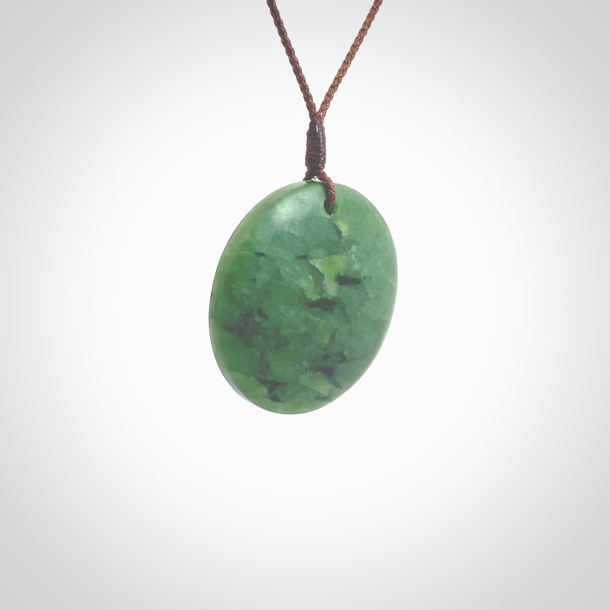 This pendant is a medium sized and cupped koru necklace carved from a lovely piece of New Zealand Jade. Kyohei Noguchi carved this piece for us so the workmanship is outstanding. Handmade in New Zealand, a beautiful piece of jade jewellery. Provided with an adjustable brown cord and packaged in a woven kete pouch.