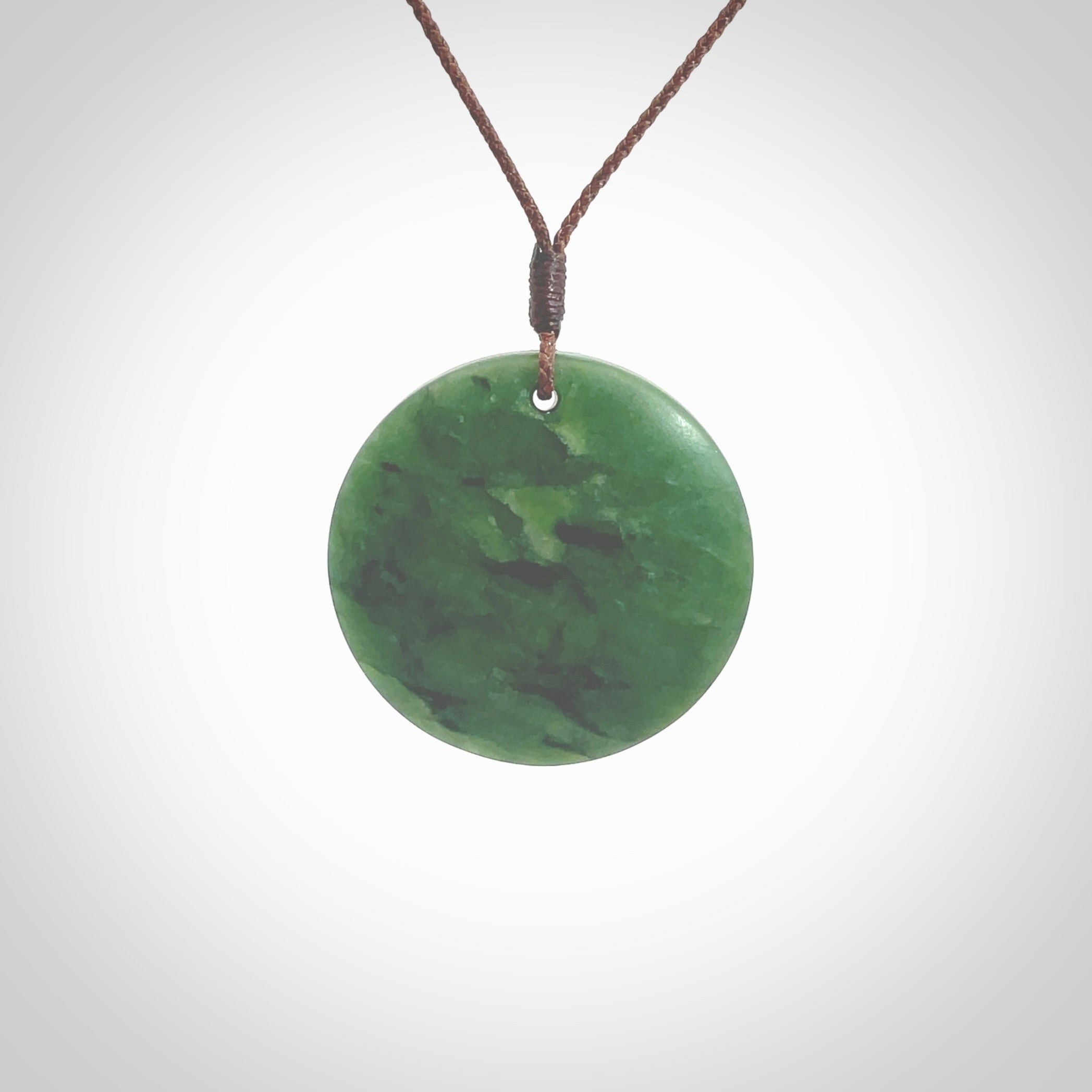 This pendant is a medium sized and cupped koru necklace carved from a lovely piece of New Zealand Jade. Kyohei Noguchi carved this piece for us so the workmanship is outstanding. Handmade in New Zealand, a beautiful piece of jade jewellery. Provided with an adjustable brown cord and packaged in a woven kete pouch.