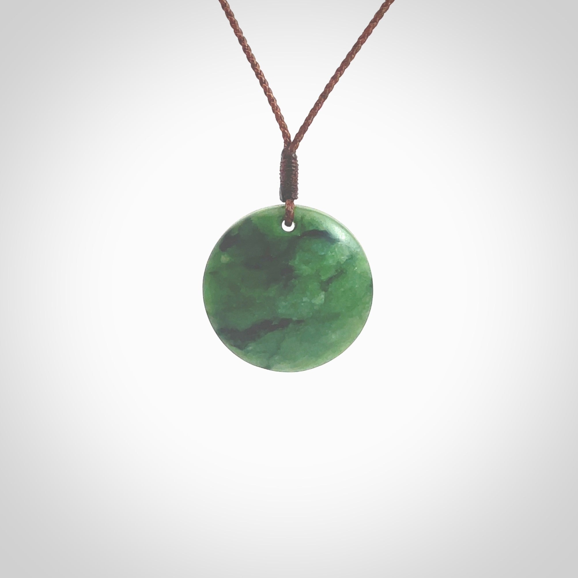 This pendant is a small sized and cupped koru necklace carved from a dark green piece of New Zealand Marsden Jade. Kyohei Noguchi carved this piece for us so the workmanship is outstanding. Handmade in New Zealand, a beautiful piece of jade jewellery. Provided with an adjustable brown cord and packaged in a woven kete pouch.