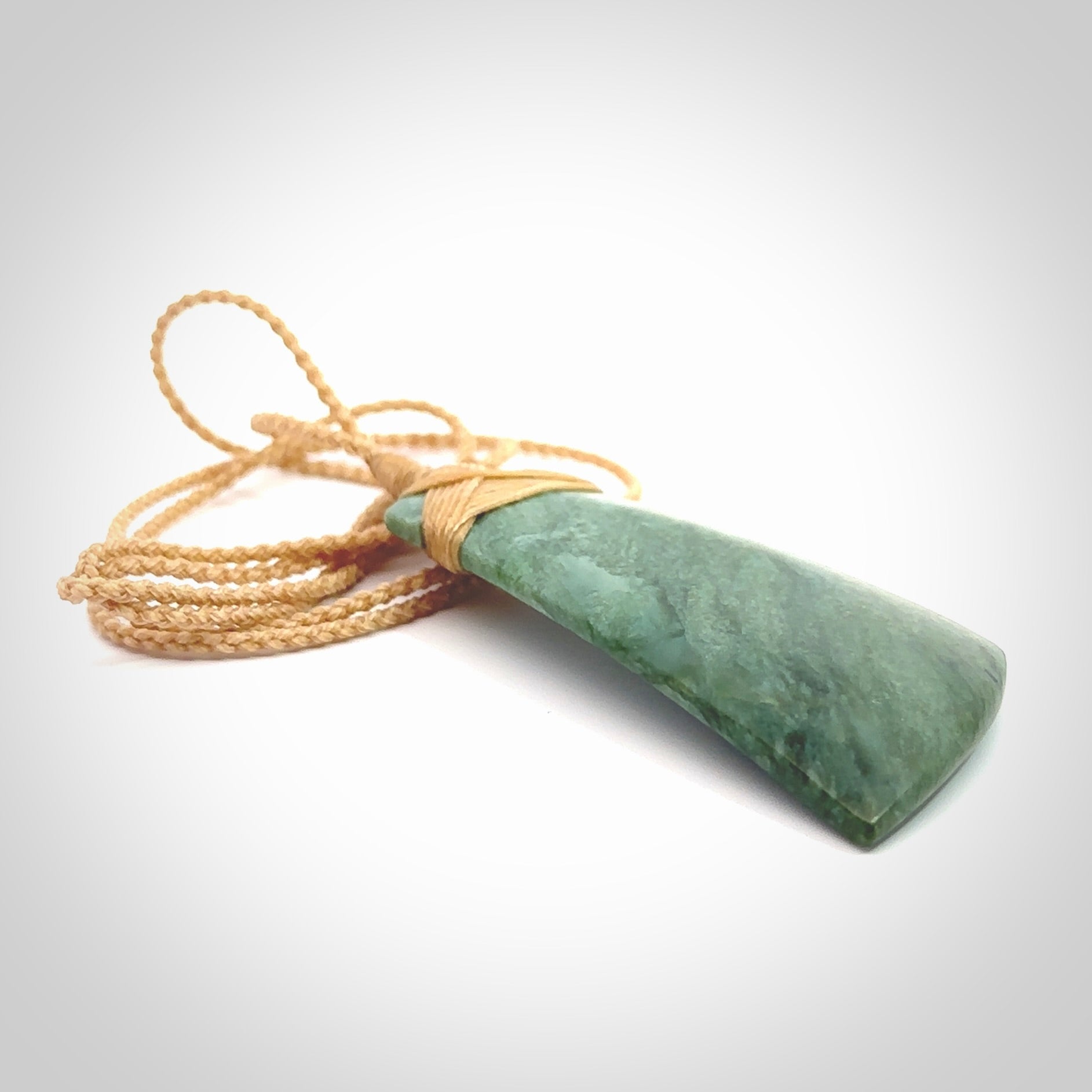 Hand carved from a lovely piece of local New Zealand Jade. The quality of the workmanship and design is outstanding - this is a piece you will want to wear all the time. We have suspended this from a 4-plait beige cord which can be adjusted with a couple of slip knots and beige binding. Hand made by Kyohei Noguchi.