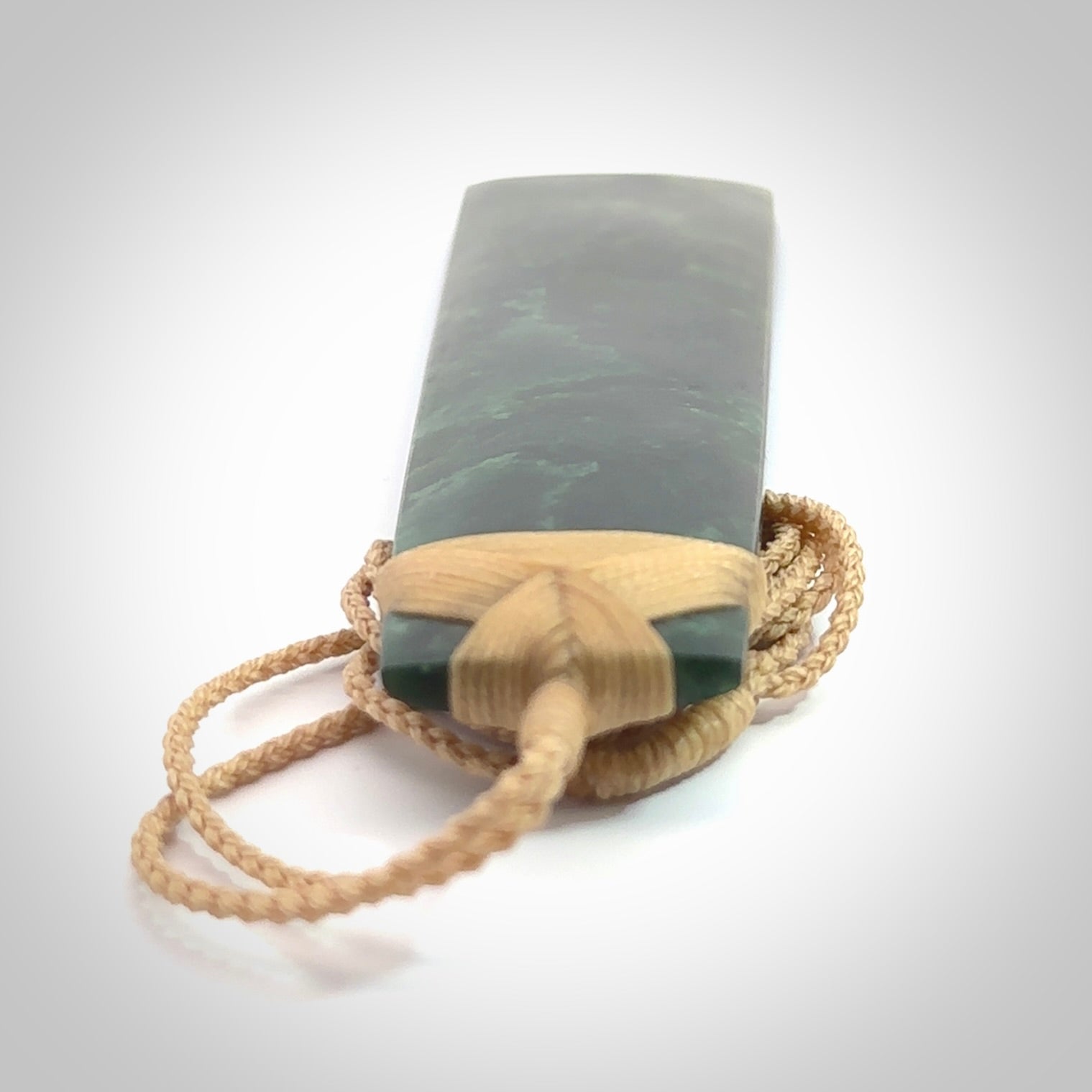 Hand carved from a lovely piece of local New Zealand Jade. The quality of the workmanship and design is outstanding - this is a piece you will want to wear all the time. We have suspended this from a 4-plait beige cord which can be adjusted with a couple of slip knots and beige binding. Hand made by Kyohei Noguchi.