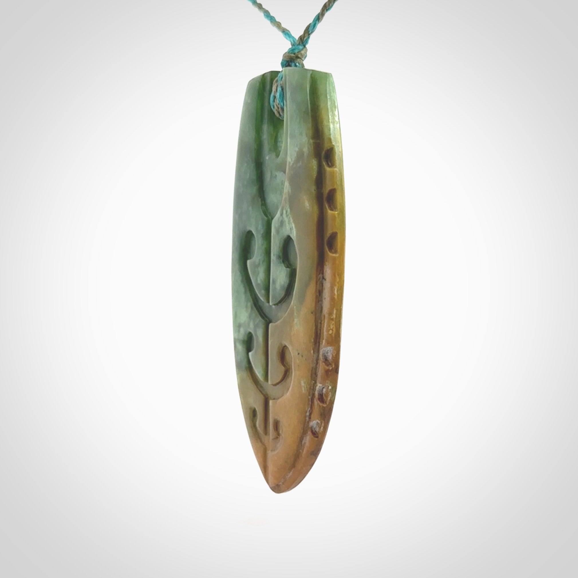 This photo shows a large Niho with koru carved into New Zealand Flower Jade. The artist, Kerry Thompson, has carved this beautifully. We have added a Mokohinau Blue/Sage Green adjustable cord. This is a fantastic work of art, we have one only.