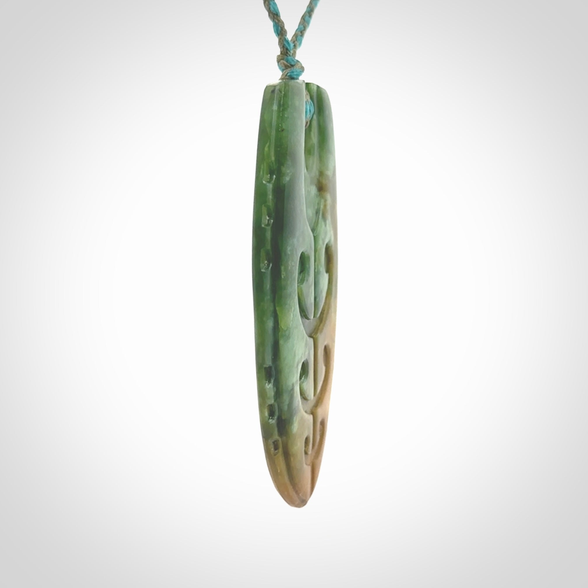 This photo shows a large Niho with koru carved into New Zealand Flower Jade. The artist, Kerry Thompson, has carved this beautifully. We have added a Mokohinau Blue/Sage Green adjustable cord. This is a fantastic work of art, we have one only.