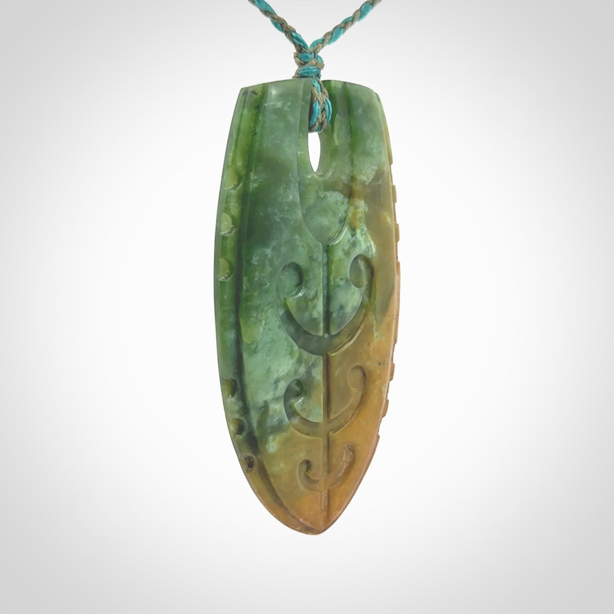 This photo shows a large Niho with koru carved into New Zealand Flower Jade. The artist, Kerry Thompson, has carved this beautifully. We have added a Mokohinau Blue/Sage Green adjustable cord. This is a fantastic work of art, we have one only.