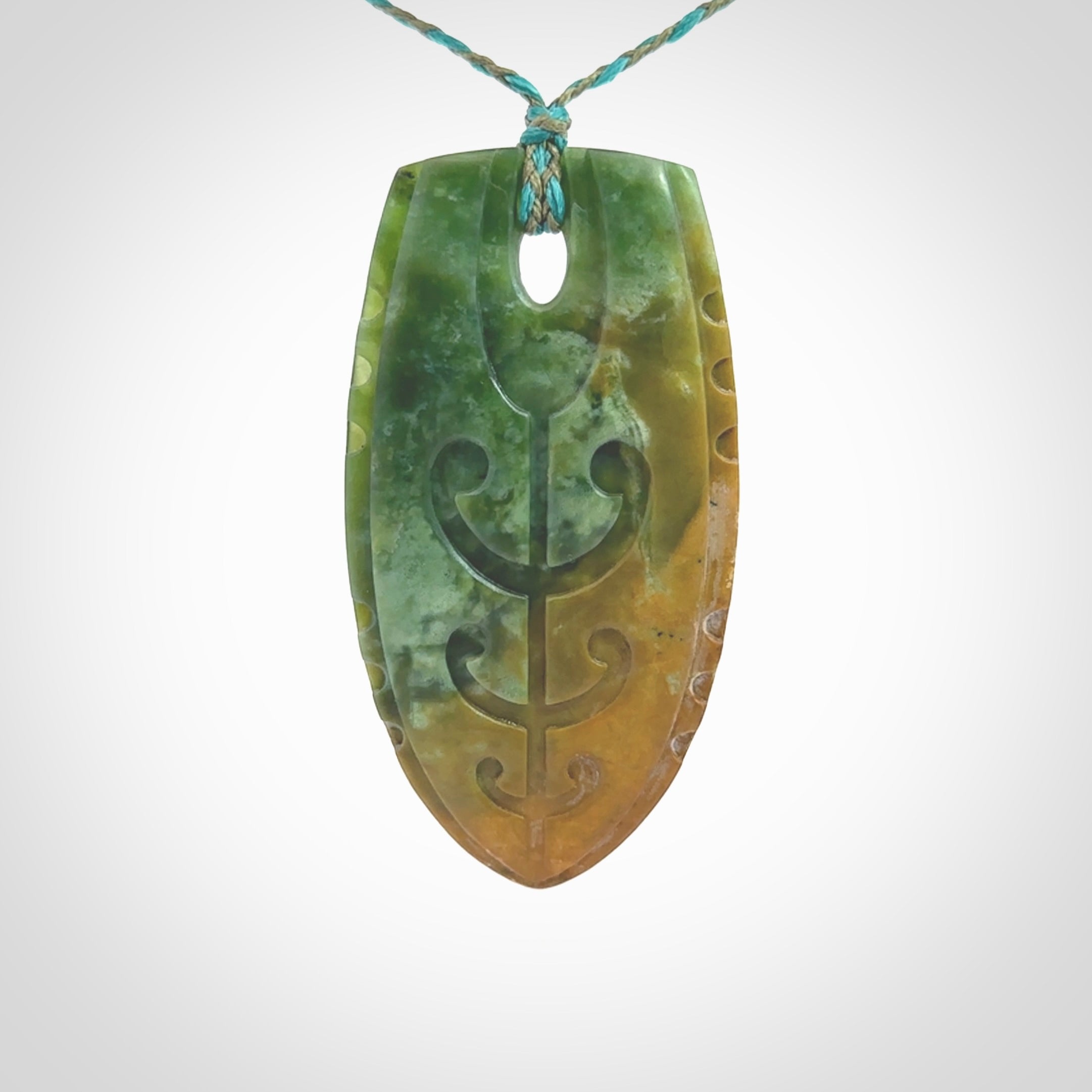 This photo shows a large Niho with koru carved into New Zealand Flower Jade. The artist, Kerry Thompson, has carved this beautifully. We have added a Mokohinau Blue/Sage Green adjustable cord. This is a fantastic work of art, we have one only.