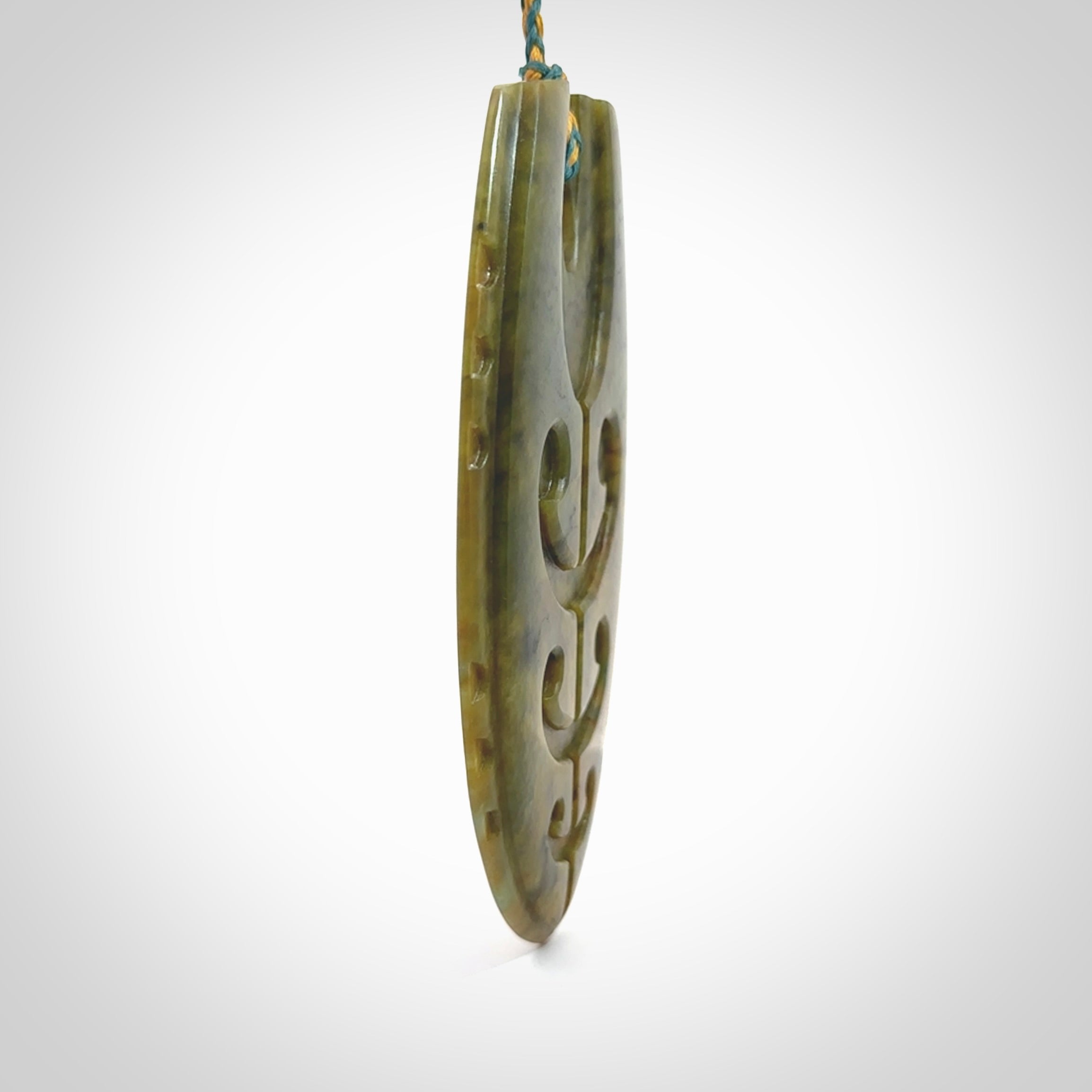 This photo shows a large Niho with koru carved into New Zealand Flower Jade. The artist, Kerry Thompson, has carved this beautifully. We have added a Sea Moss Blue/Harvest Gold adjustable cord. This is a fantastic work of art, we have one only.