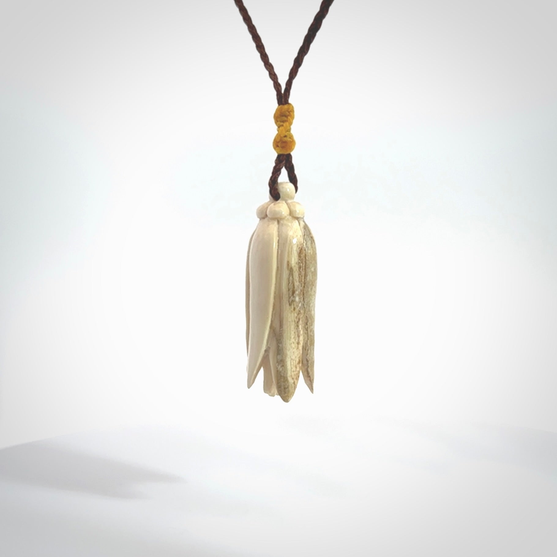 Hand carved Kowhai flower. These are made from Woolly Mammoth tusk and are a soft golden brown colour. They are provided with a hand plaited, adjustable cord. Shipping is free worldwide.