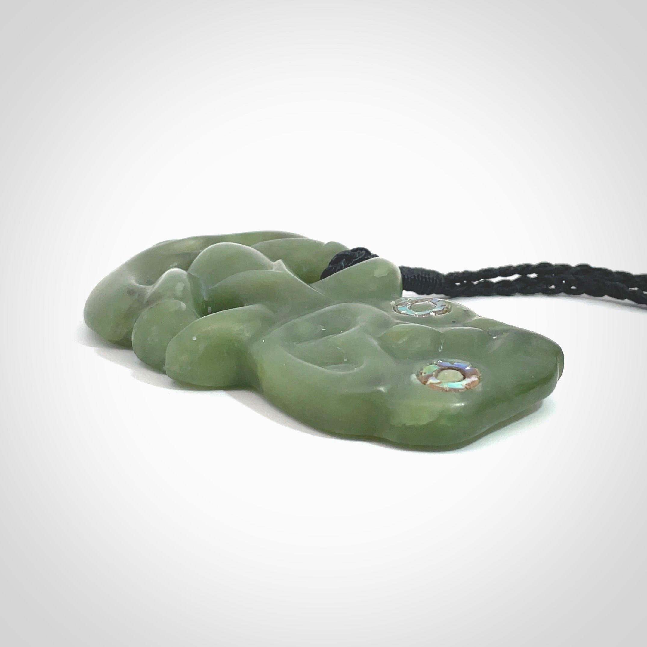 This is a large sized tiki - carved from gorgeous Marsden jade. The craftsmanship is superb, this piece is as well carved as any we have seen. The cord is an adjustable thick black and we packaged this gorgeous Pounamu Tiki in a woven kete pouch.