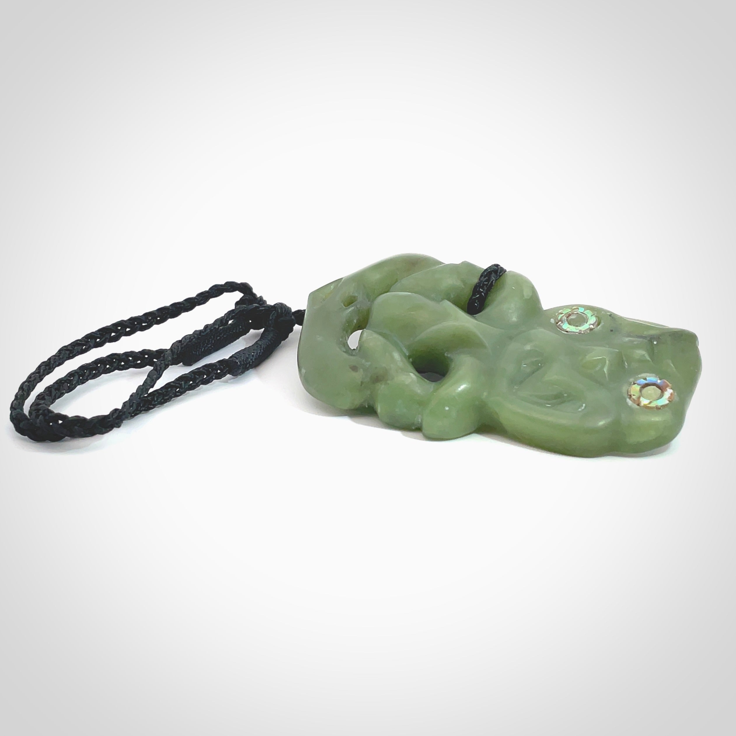 This is a large sized tiki - carved from gorgeous Marsden jade. The craftsmanship is superb, this piece is as well carved as any we have seen. The cord is an adjustable thick black and we packaged this gorgeous Pounamu Tiki in a woven kete pouch.