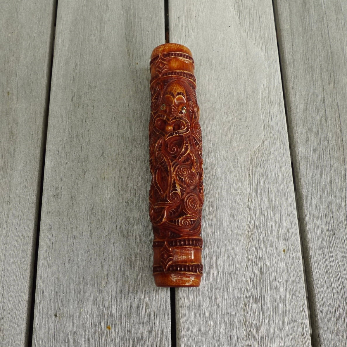 A traditional hand carved Māori flute. This piece is made from bone and is a fully functioning musical instrument and can be played. Beautiful ethnic art hand made by NZ Pacific. Hand made by Yuri Terenyi, one only stained bone flute instrument. Traditional art from New Zealand.