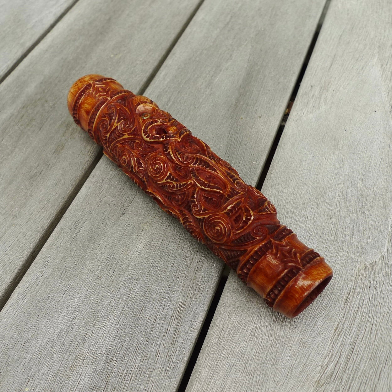 A traditional hand carved Māori flute. This piece is made from bone and is a fully functioning musical instrument and can be played. Beautiful ethnic art hand made by NZ Pacific. Hand made by Yuri Terenyi, one only stained bone flute instrument. Traditional art from New Zealand.