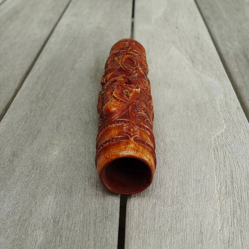 A traditional hand carved Māori flute. This piece is made from bone and is a fully functioning musical instrument and can be played. Beautiful ethnic art hand made by NZ Pacific. Hand made by Yuri Terenyi, one only stained bone flute instrument. Traditional art from New Zealand.